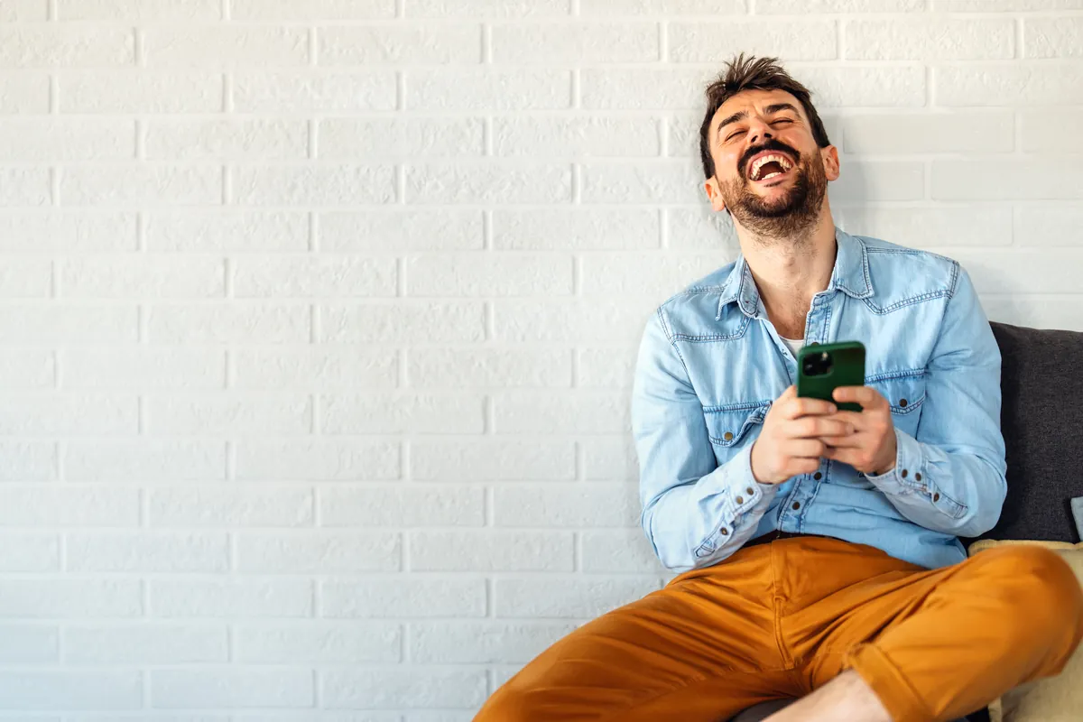 Homme ravi regardant son smartphone après une réponse rapide à sa demande de crédit