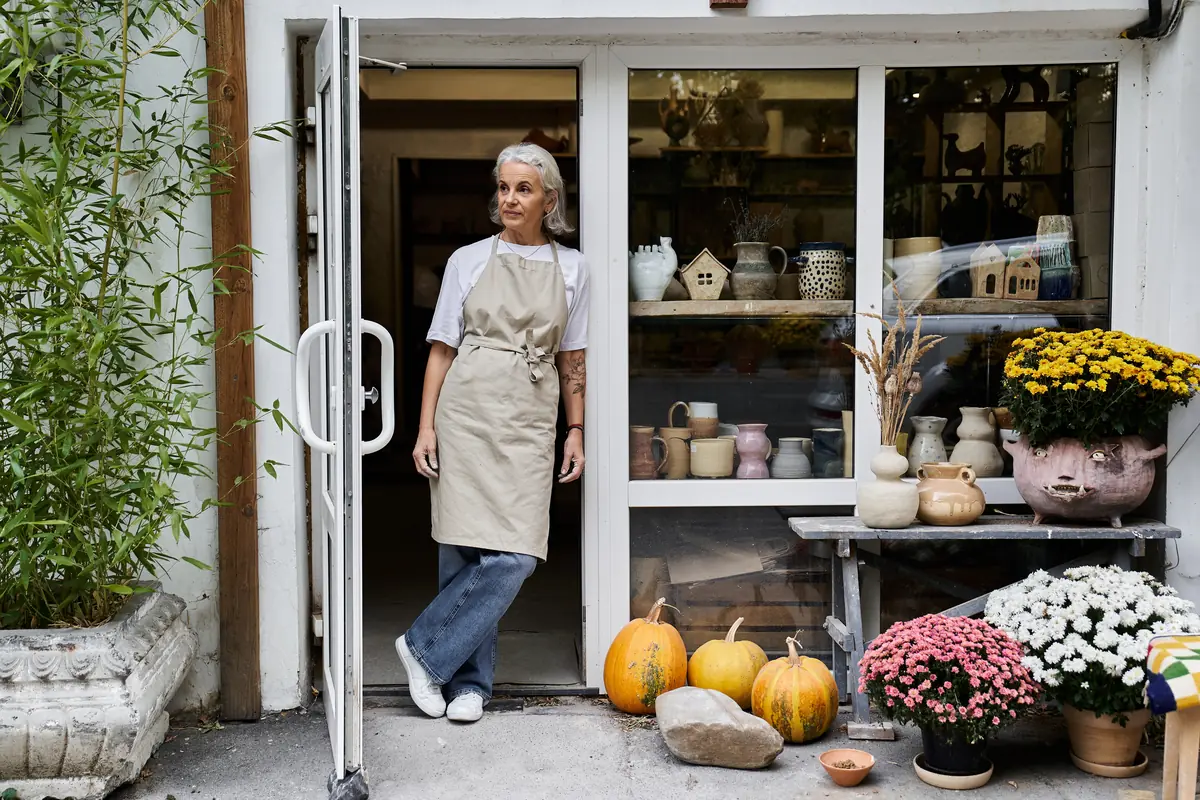 Commerçante devant sa boutique de poterie financée par un micro crédit