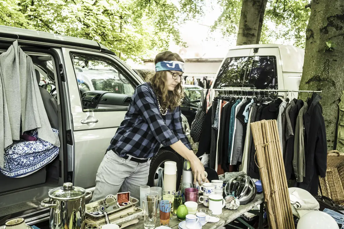Femme vendant des vêtements d'occasion sur un marché en plein air