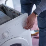 Homme réparant une machine à laver en panne à la maison