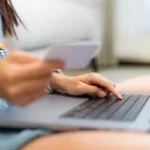 Femme payant un achat en ligne avec sa carte bancaire sur ordinateur