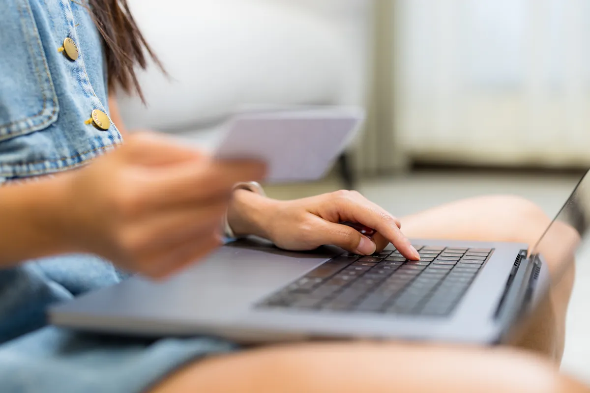 Femme payant un achat en ligne avec sa carte bancaire sur ordinateur