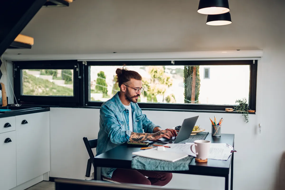 Homme travaillant en freelance sur son ordinateur dans un bureau lumineux