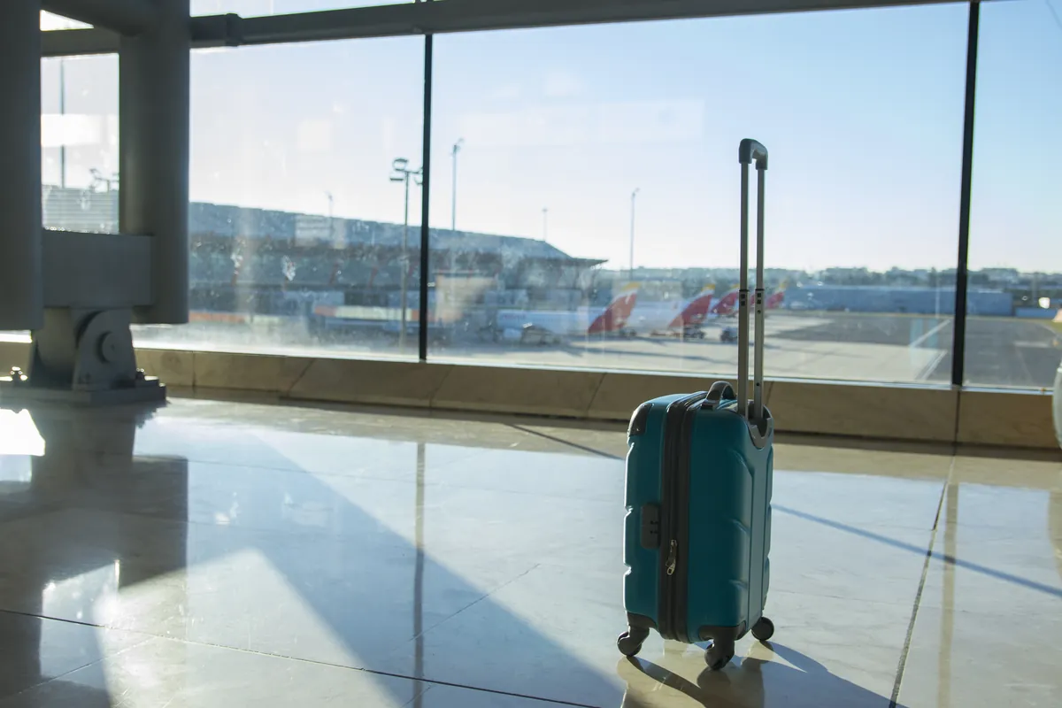 Valise bleue dans un terminal d'aéroport avant un voyage financé à crédit