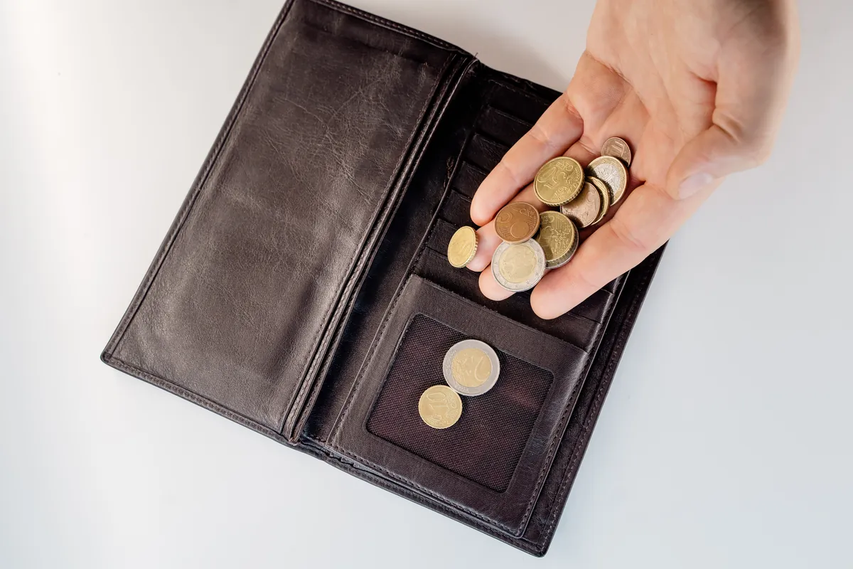 Portefeuille ouvert et pièces de monnaie sur une table
