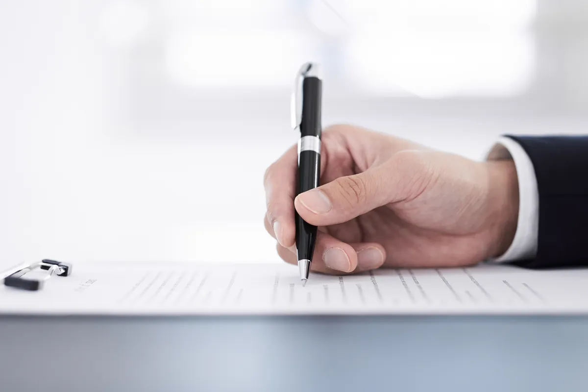 Main signant un contrat de prêt sur un bureau