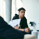 Jeune en rendez-vous avec un conseiller pour demander une aide financière