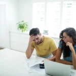 Couple inquiet examinant ses finances à la table de la cuisine