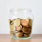 Bocal rempli de pièces en euros sur une table en bois