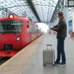 Voyageur avec sa valise attendant le train sur le quai d'une gare