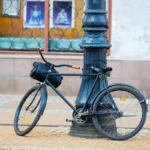 Vélo rétro garé contre un poteau dans une rue