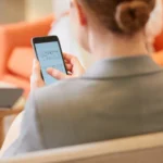 Femme consultant son smartphone, vue de dos