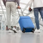 Voyageurs tirant leurs valises dans un hall d'aéroport