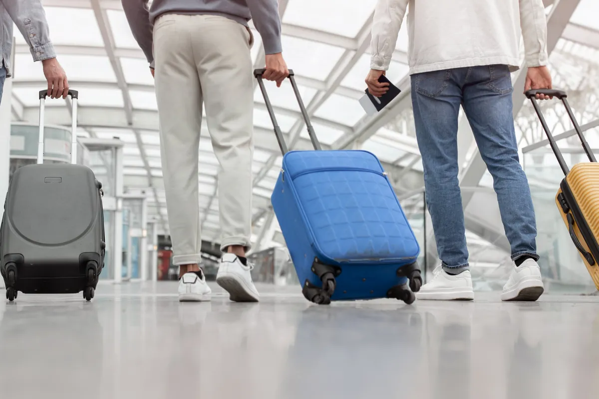 Voyageurs tirant leurs valises dans un hall d'aéroport
