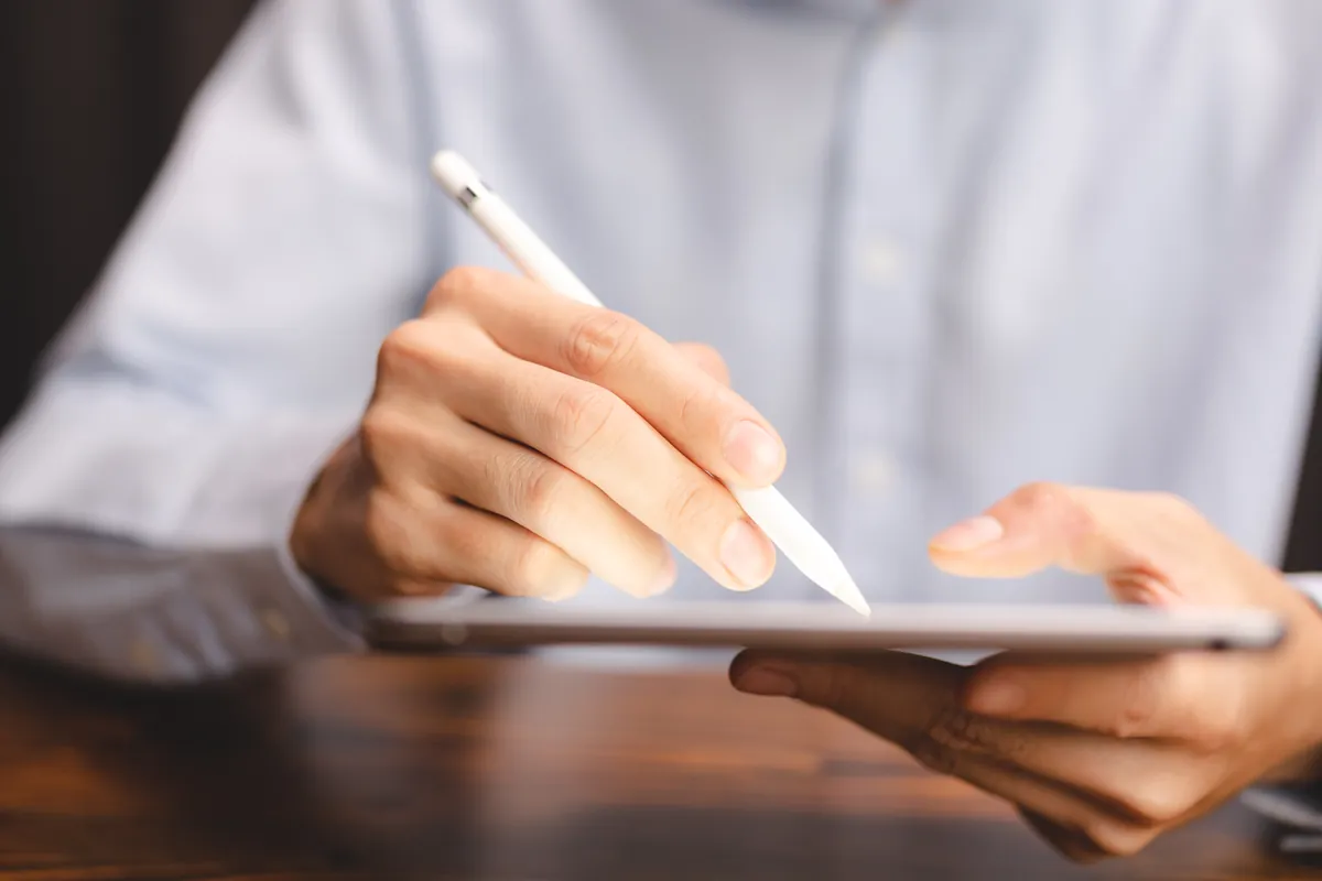 Mains signant électroniquement une demande de crédit sur tablette