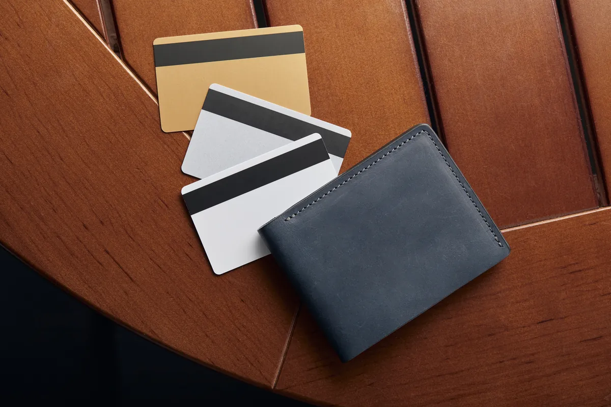 Portefeuille bleu et cartes bancaires sur une table en bois