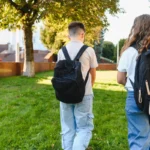 Deux élèves avec leur sac à dos marchant vers l'école