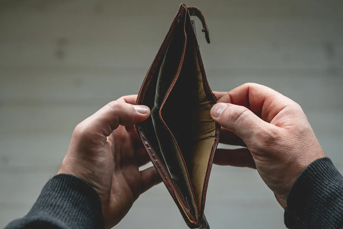 Mains ouvrant un portefeuille vide