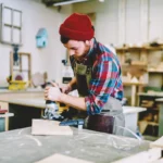 Artisan menuisier travaillant le bois dans son atelier