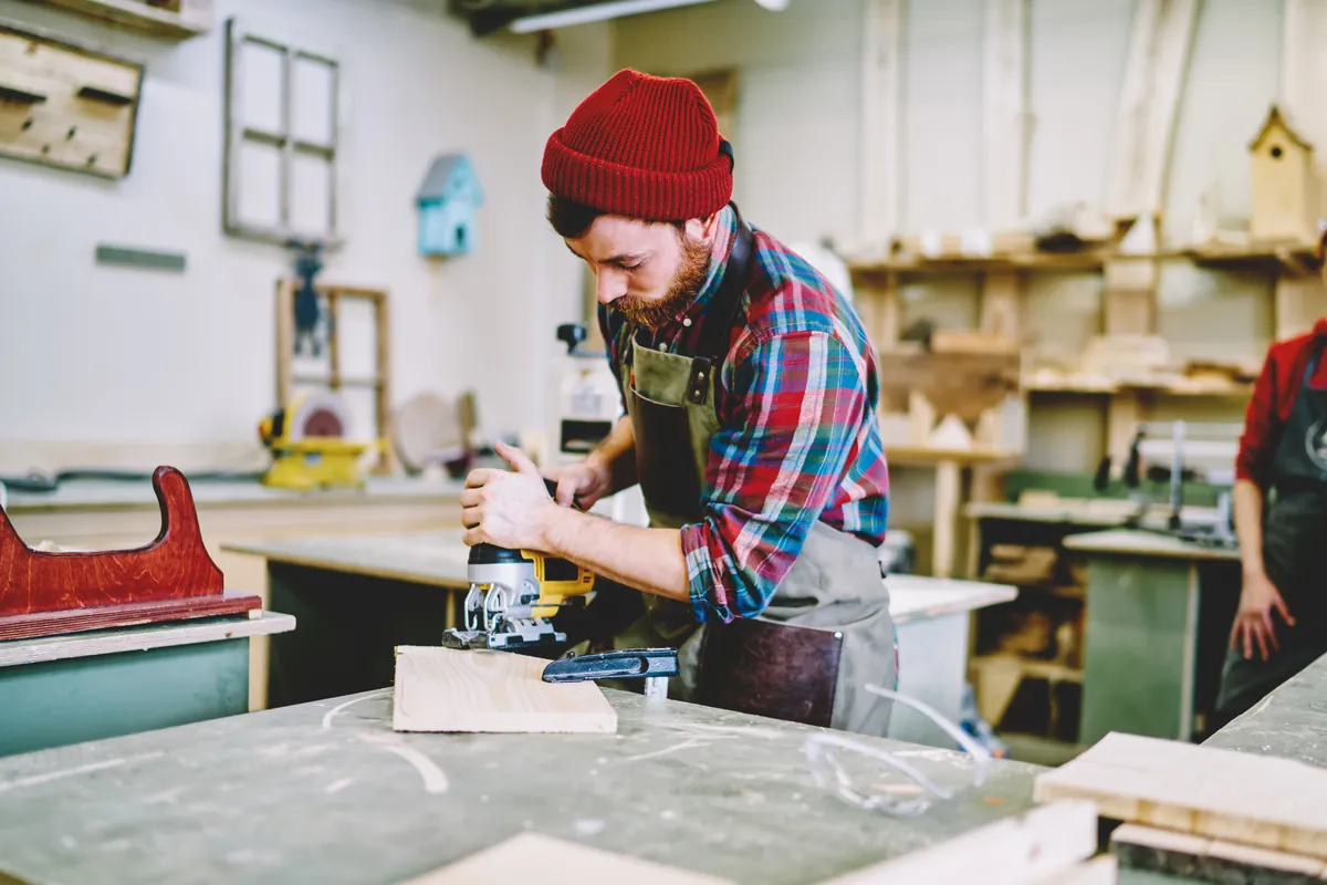 Artisan menuisier travaillant le bois dans son atelier