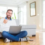 Homme satisfait devant son ordinateur levant le pouce