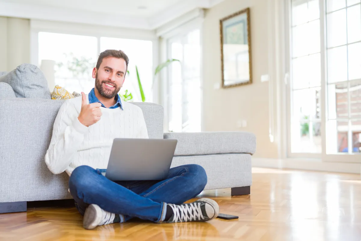 Homme satisfait devant son ordinateur levant le pouce