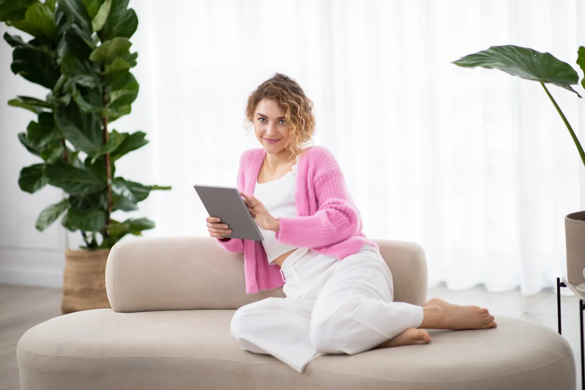 Femme détendue chez elle utilisant une tablette