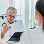 Médecin examinant un dossier médical avec un patient