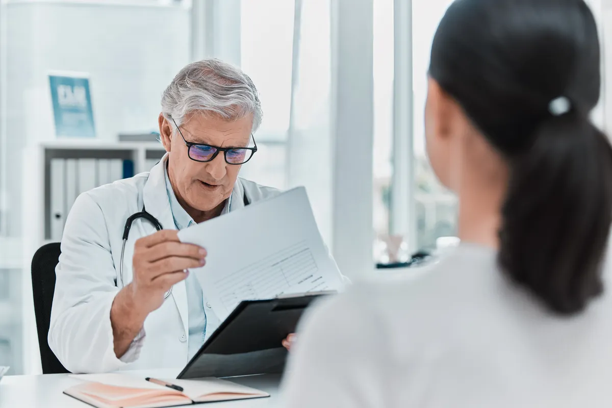 Médecin examinant un dossier médical avec un patient
