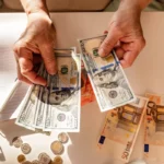 Mains comptant des billets sur une table