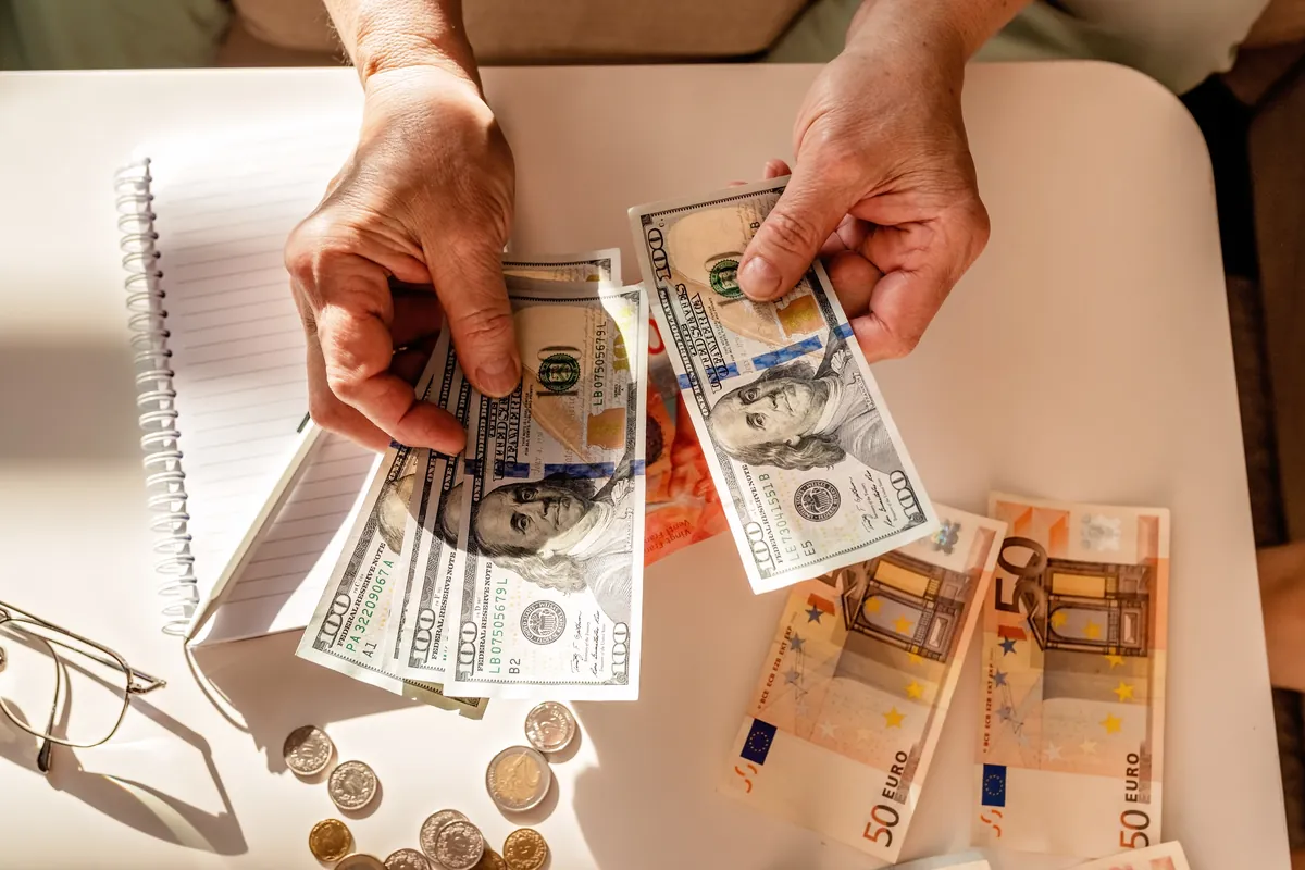 Mains comptant des billets sur une table