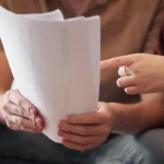 Couple étudiant ensemble les documents d'un financement à la maison