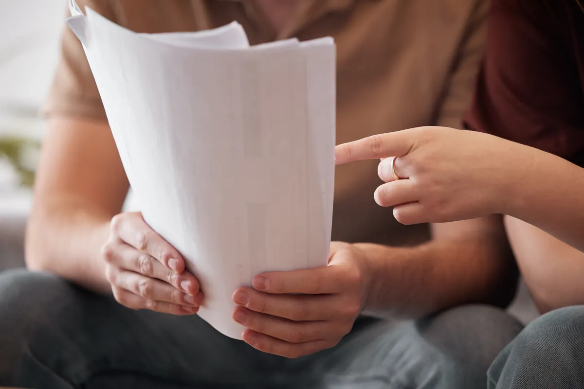 Couple étudiant ensemble les documents d'un financement à la maison