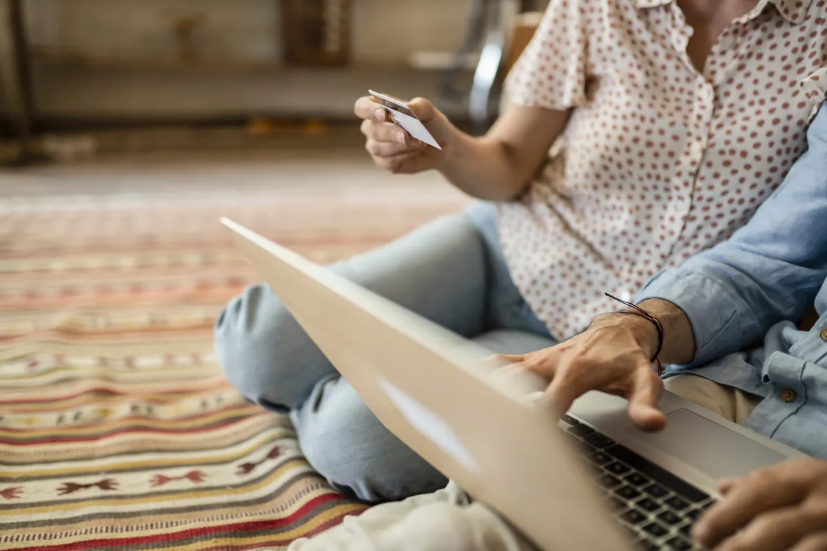 Couple réglant un achat en ligne avec une carte bancaire sur ordinateur