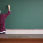 Enseignant écrivant au tableau noir dans une salle de classe